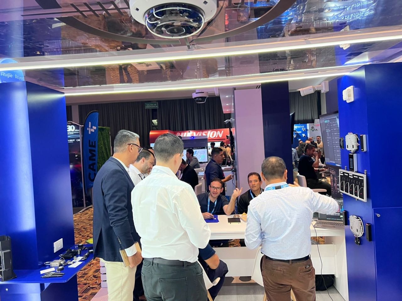 Stand de CAME con visitantes y piso de exposición al fondo con Hikvision