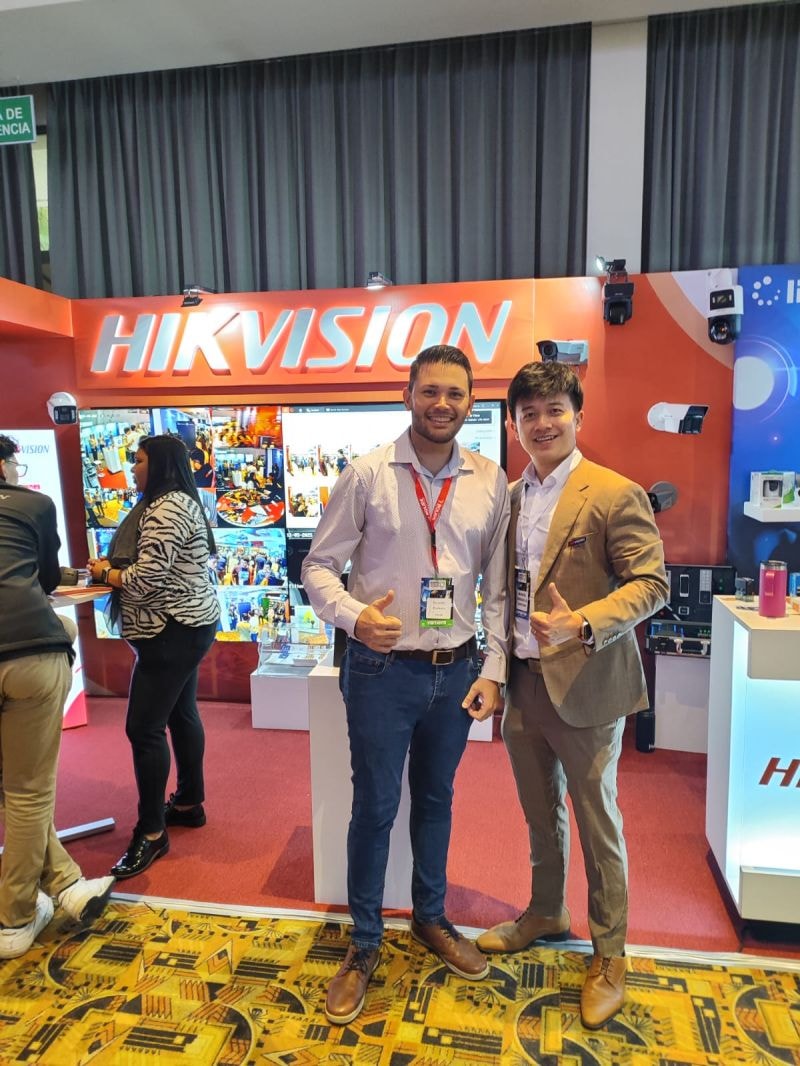 Dos personas posando frente al stand de Hikvision