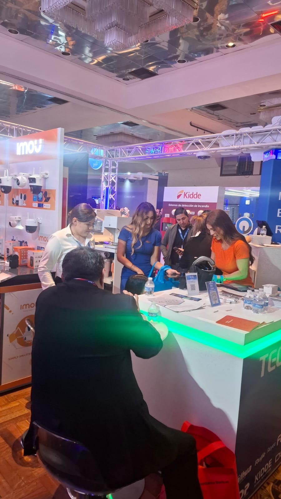 Piso de exposición con stands de Imou y Kidde con visitantes
